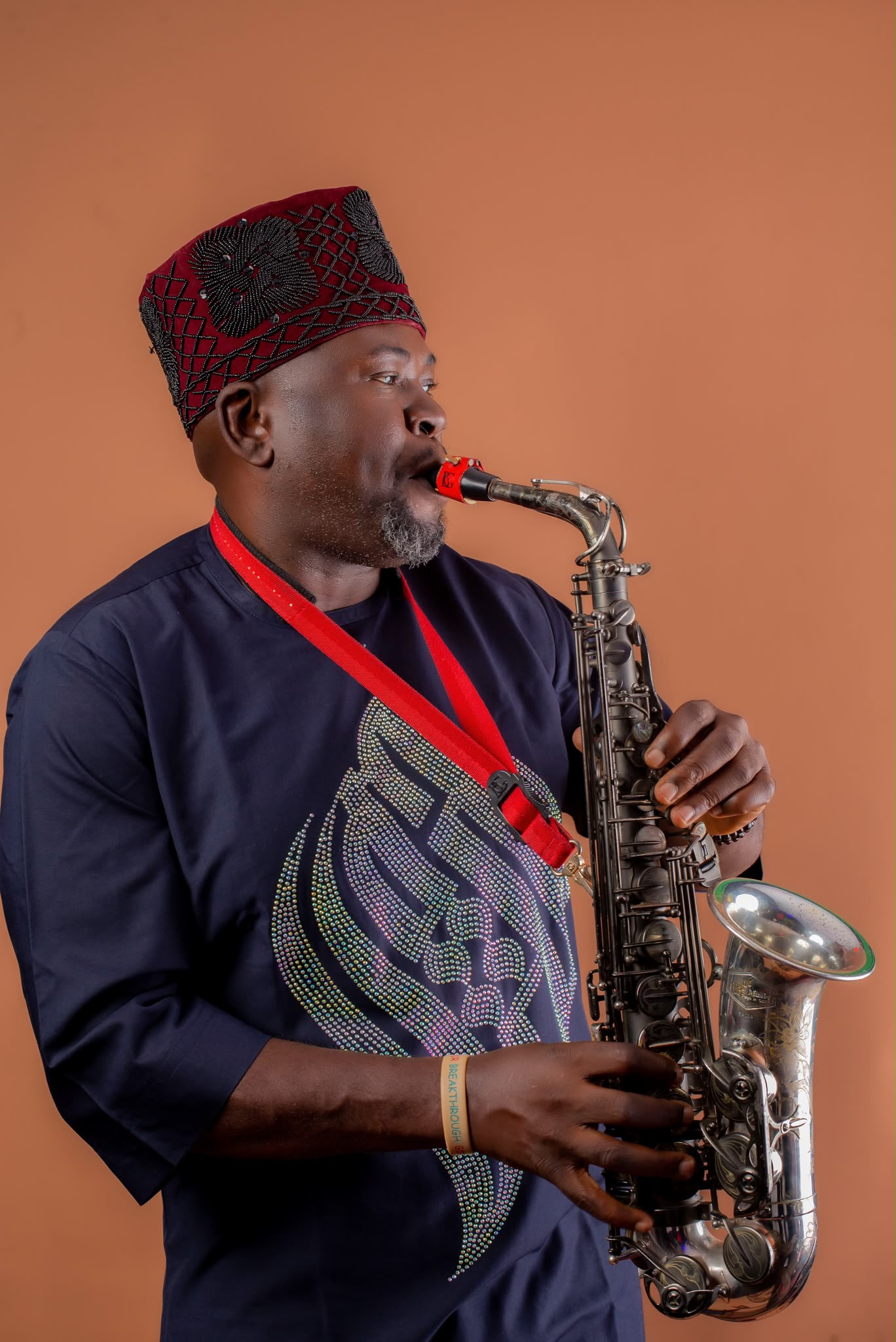 Segun Oluwayomi playing saxophone in deep concentration during AlujoHymn Fusion session